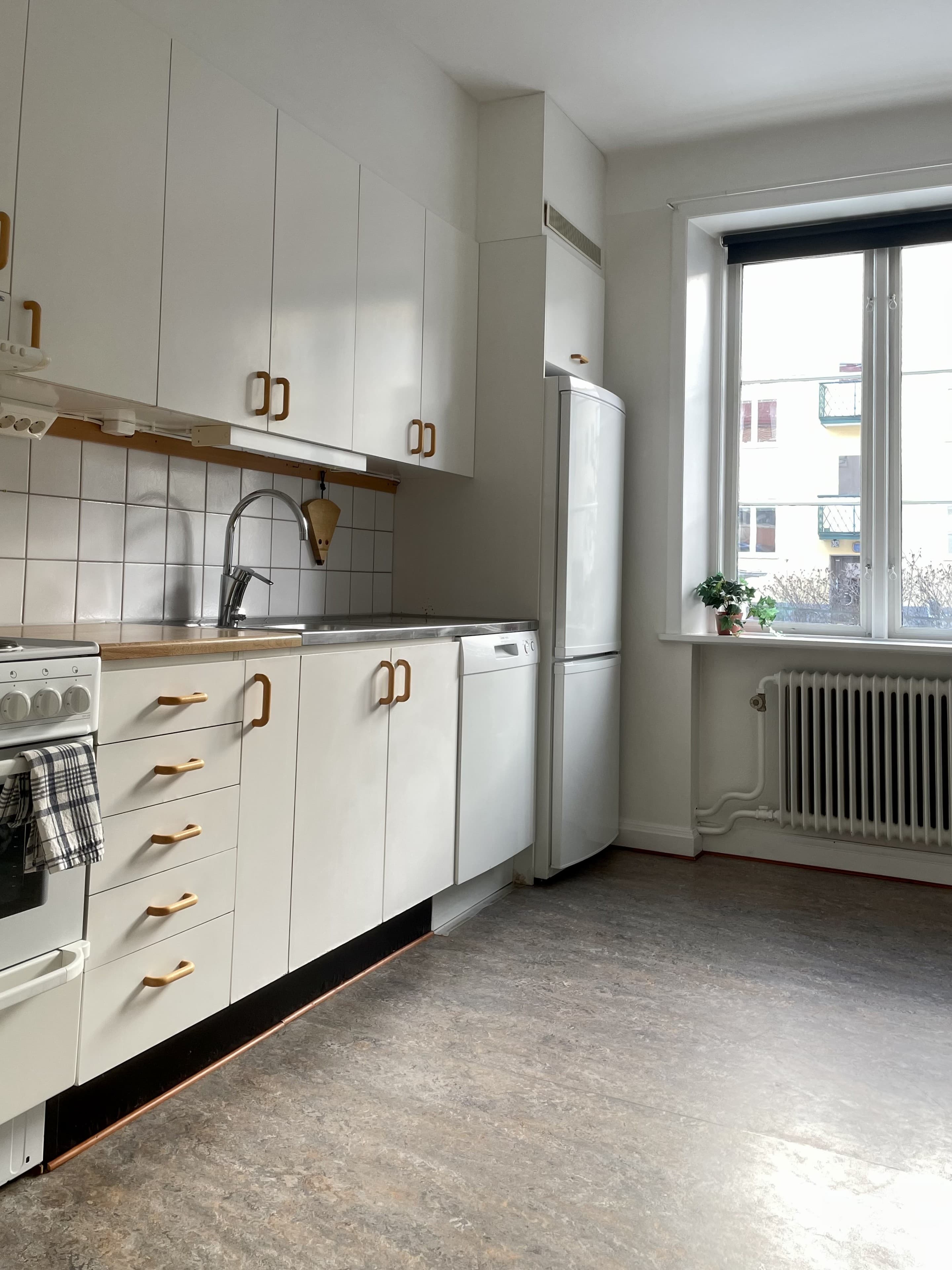 Kök med diskmaskin och kylskåp